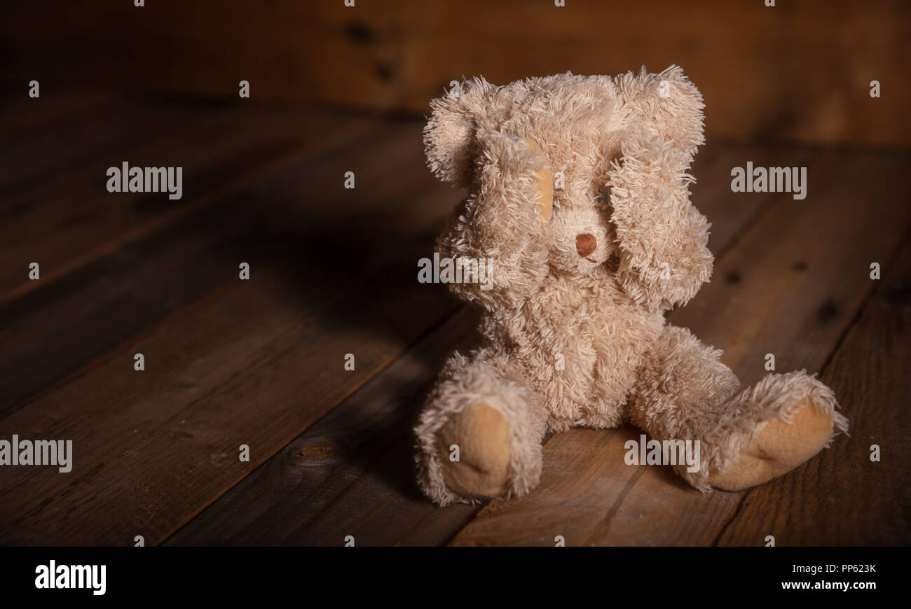 Kindesmissbrauch Konzept. Teddy Bear mit Augen, dunkle leeren Hintergrund, kopieren Raum Stockfoto
