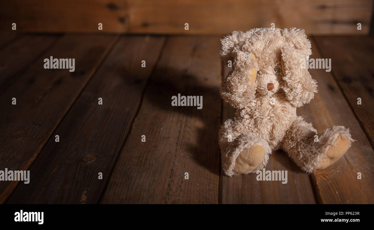 Kindesmissbrauch Konzept. Teddy Bear mit Augen, dunkle leeren Hintergrund, kopieren Raum Stockfoto