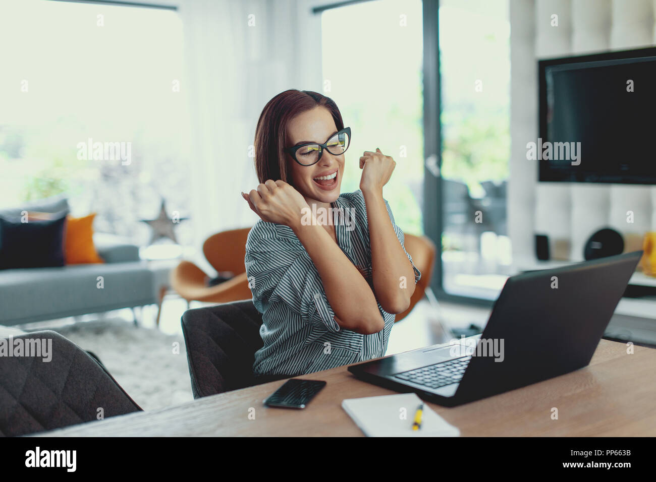 Junge Glück succeessful Frau Euphorie, die Anwendung oder Prüfung auf Laptop, im Innenbereich Stockfoto