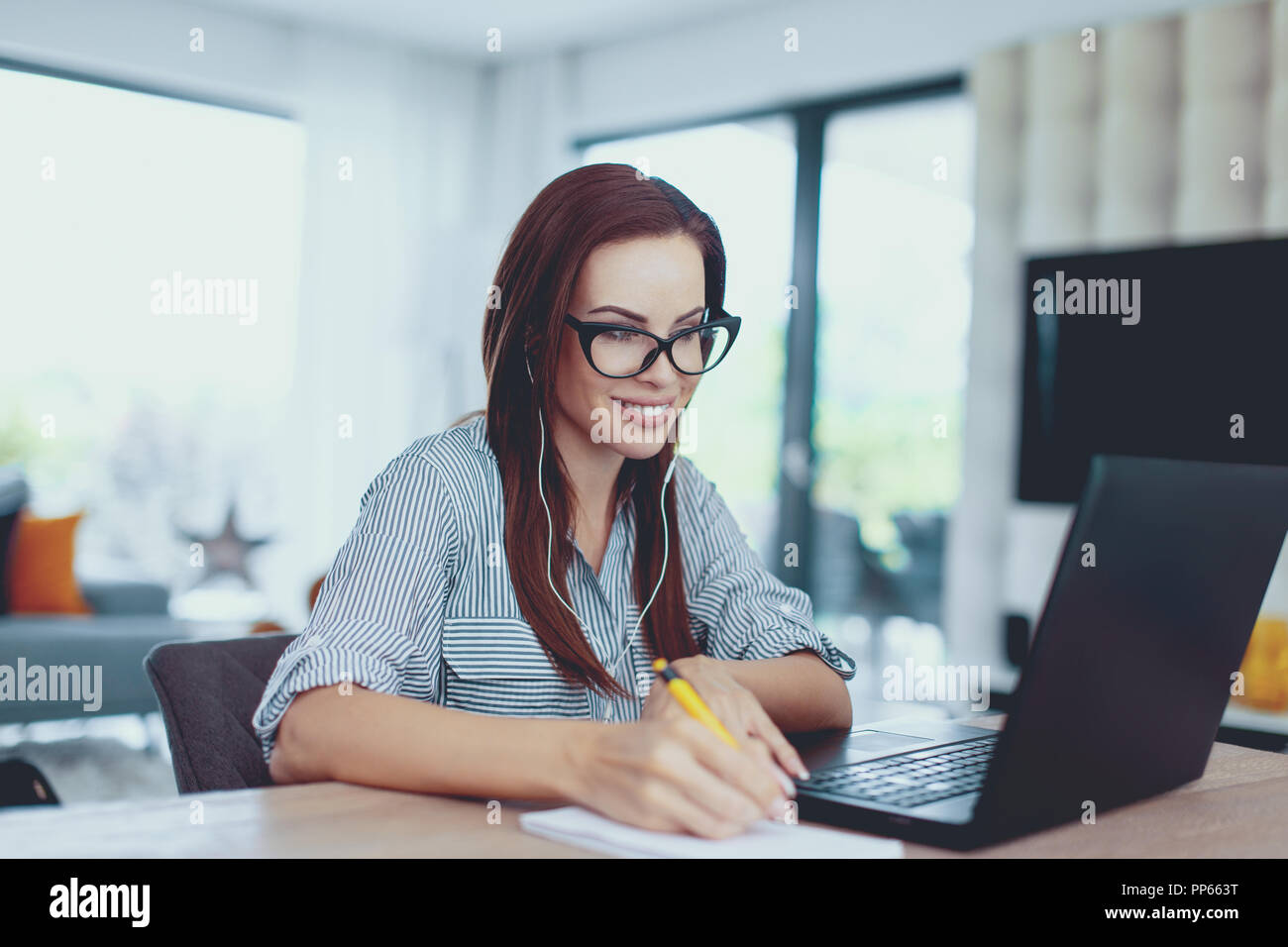 Junge nerd Frau Notizen in Innenräumen, toothy Lächeln Stockfoto