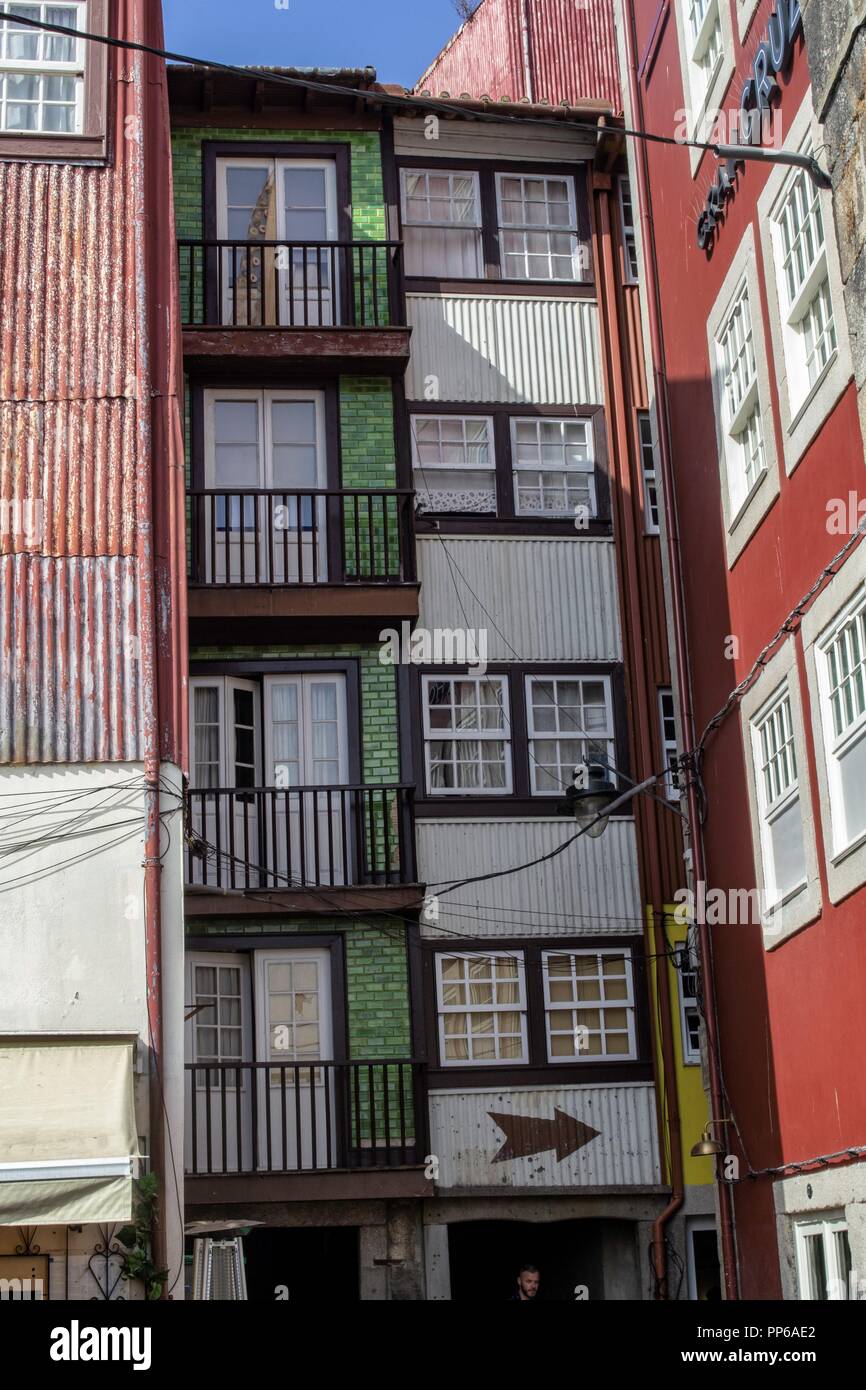 Porto, Portugal EINE Seitenstraße in Porto, Portugal mit vielen bunten Häusern, darunter scheinbar mit gewellten Wänden. Stockfoto