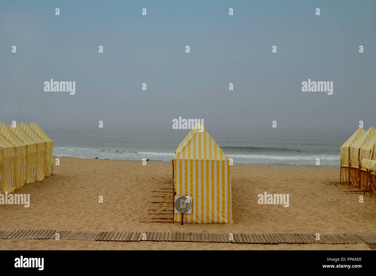 Espinho, Portugal. Einsame Strandszene mit Strandhütten und kein Anzeichen von menschlicher Aktivität an einem trüben sonnigen Tag. Stockfoto