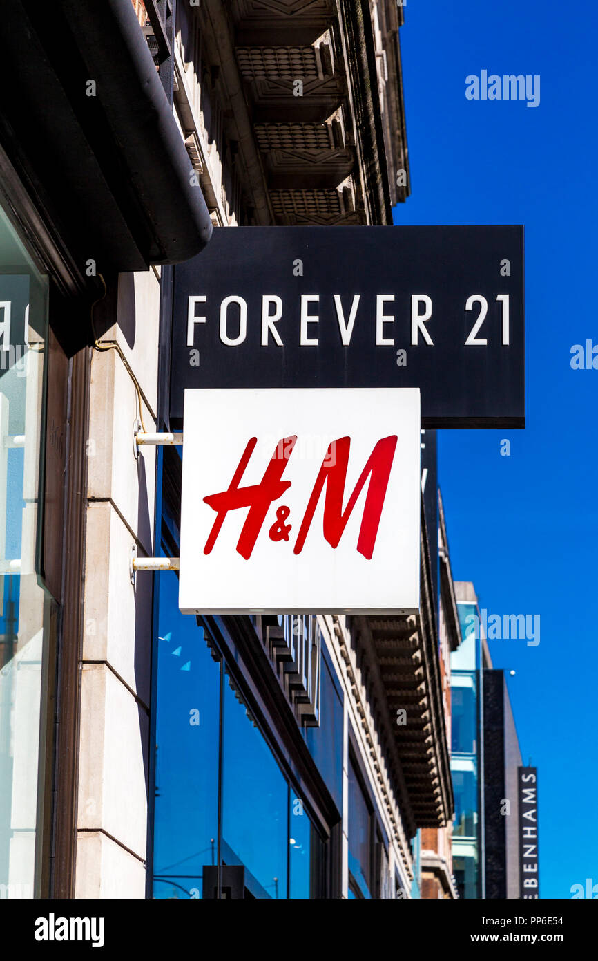 Anzeichen für H&M und für Immer 21 Kleidung Marken und Läden in der Oxford Street, London, UK Stockfoto