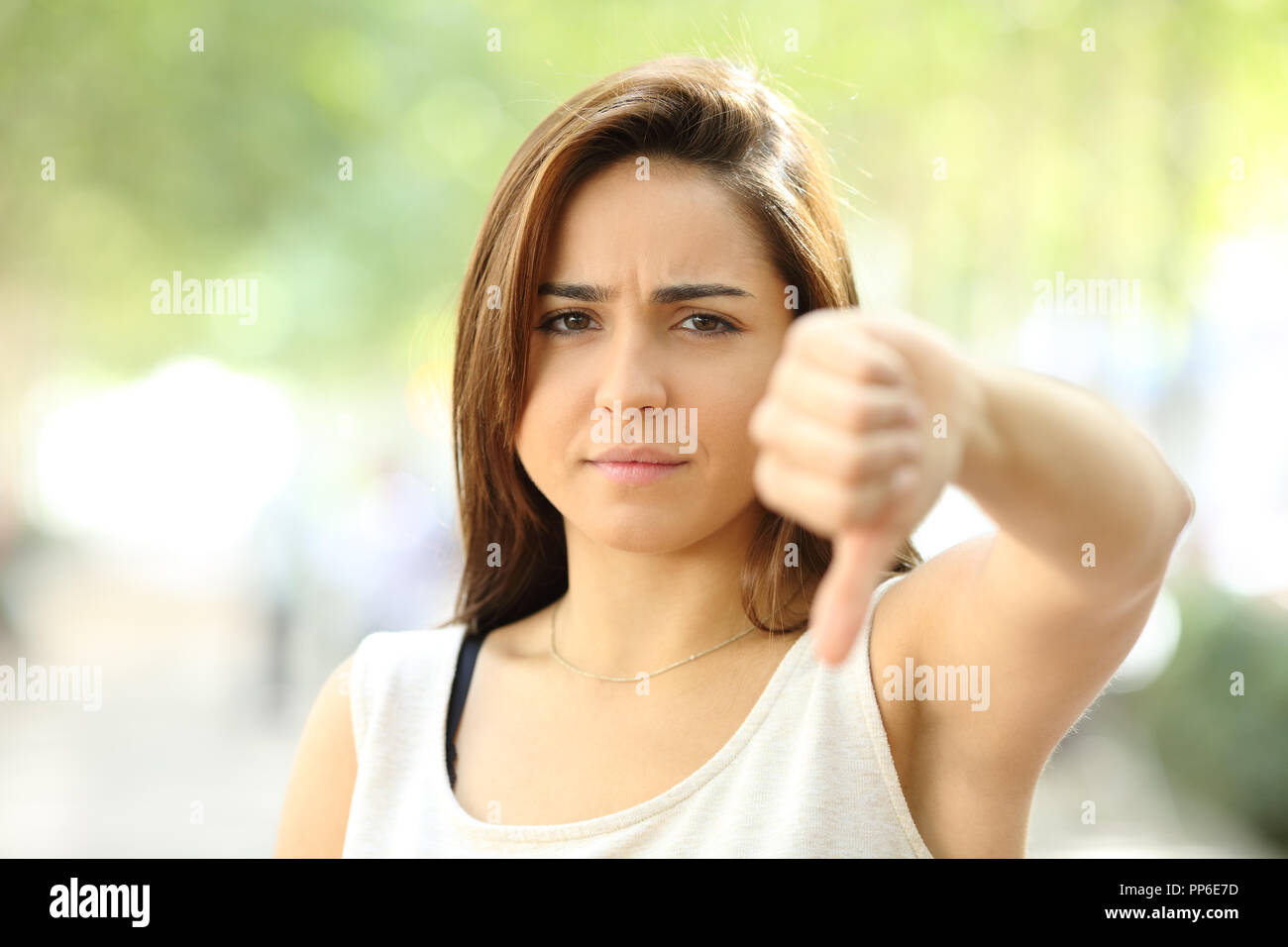 Vorderansicht Portrait von einem wütenden jugendlich sich weigern, mit Daumen nach unten auf der Straße Stockfoto