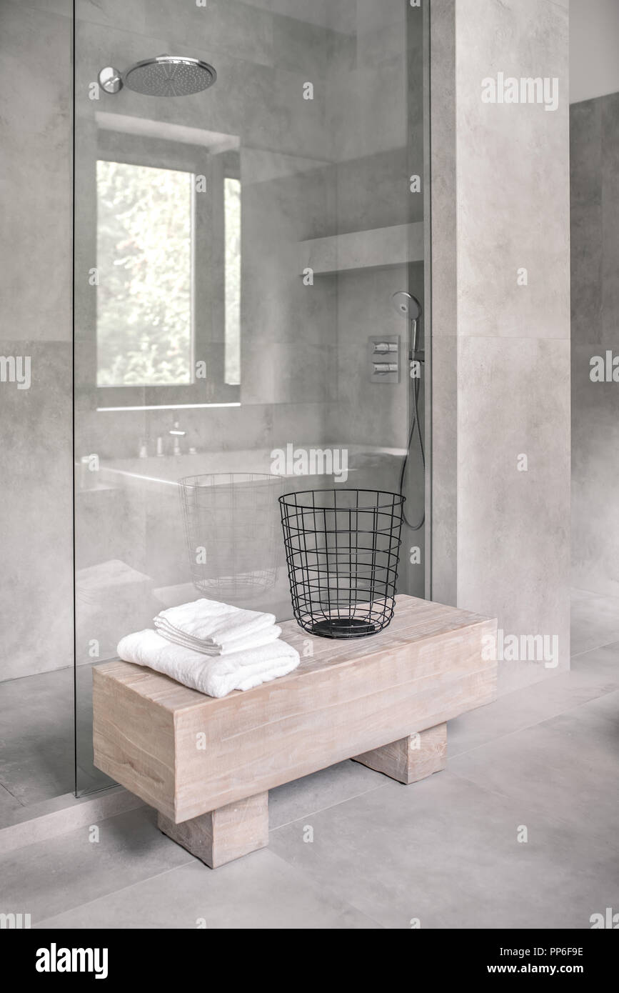 Stilvolles Modernes Bad Mit Fliesen Grauen Wanden Es Gibt Eine Dusche Mit Glastur Stand Aus Holz Mit Weissen Handtuchern Ana Ein Metall Schwarz Warenkorb Vertikale Stockfotografie Alamy