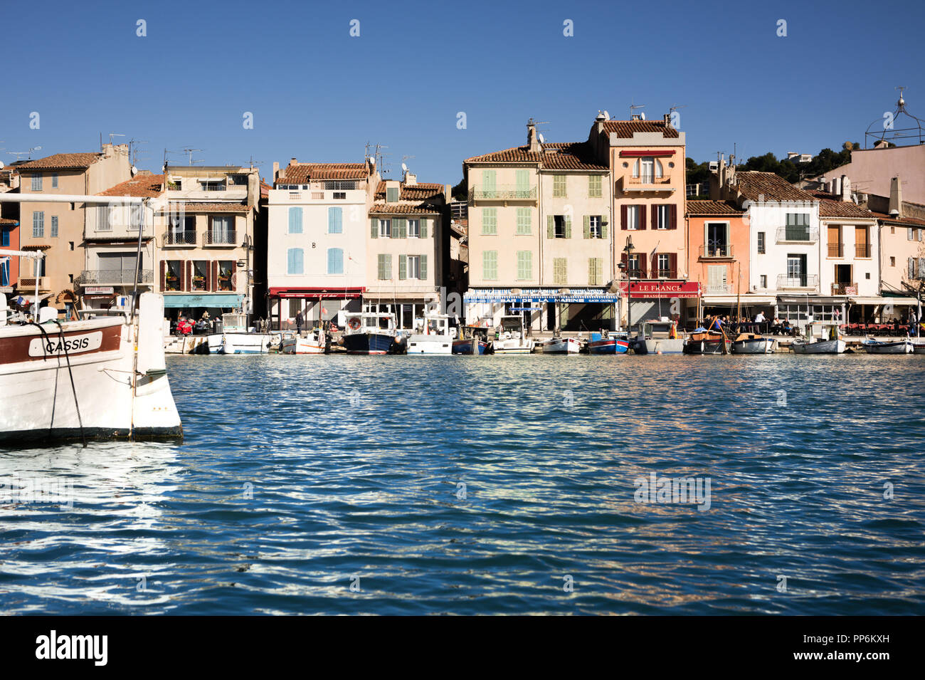 Der ruhige Hafen der alten Cassis in Frankreich im Sonnenlicht, Frontansicht mit Boot. Stockfoto