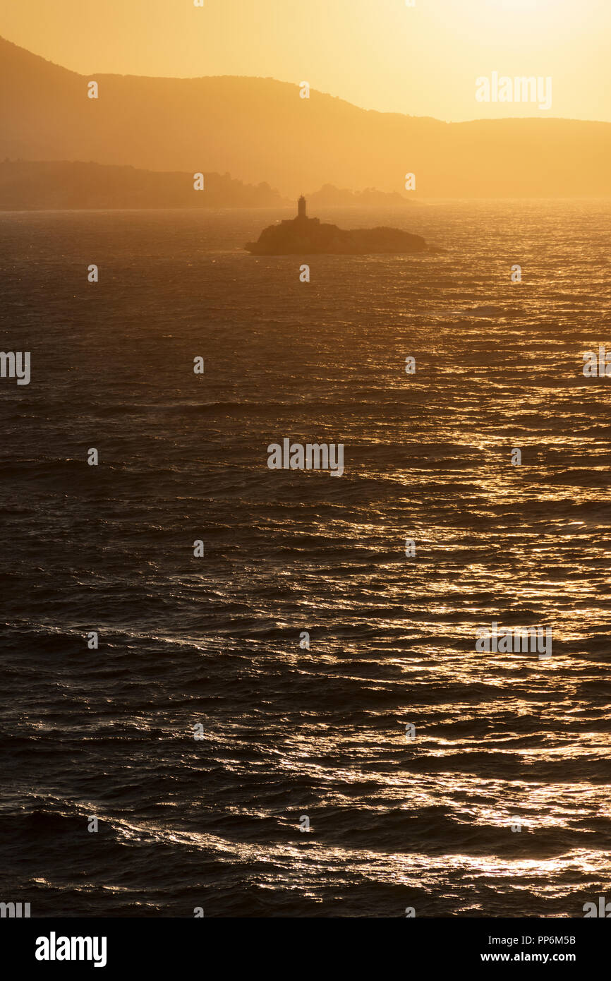 Leuchtturm auf Insel bei Sonnenuntergang zwischen stürmischem Meer. Leuchttürme von Griechenland "Peristeres Kaparelli" befindet sich an der nord-östlichen Spitze der Insel Korfu. Stockfoto