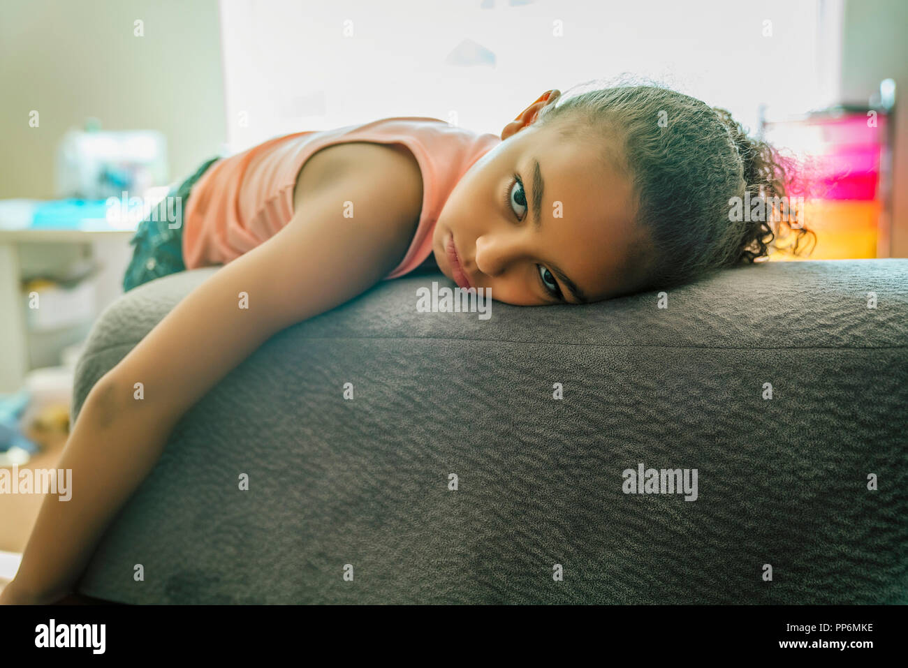 Gemischte gelangweilt-race Girl schmollend auf der Couch Stockfoto