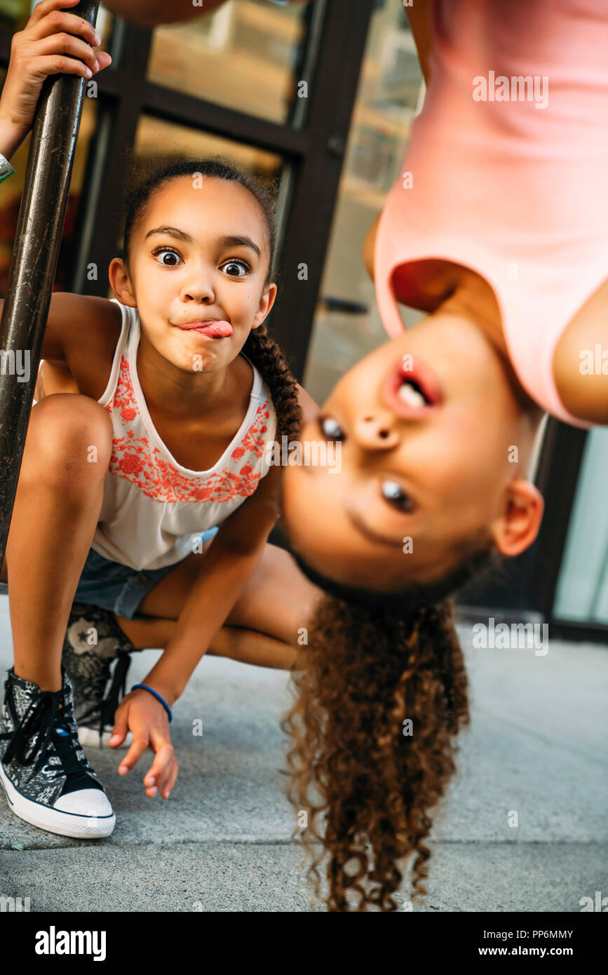 Glücklich lächelnde Mädchen hängen von Bike Rack bar auf Bürgersteig Stockfoto