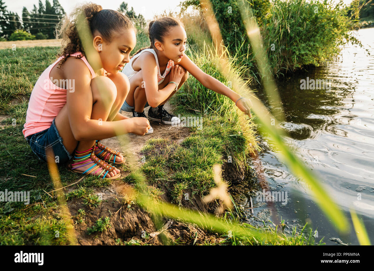 Mädchen, die durch den Rand eines Sees in einem Park Stockfoto