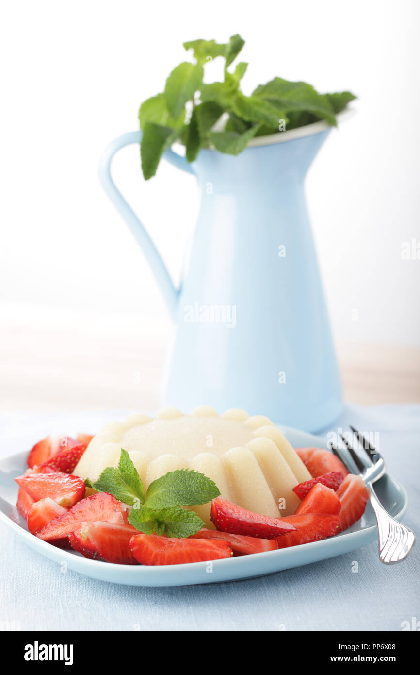 Grießbrei mit in Scheiben geschnittenen Erdbeeren und Pfefferminze Stockfoto