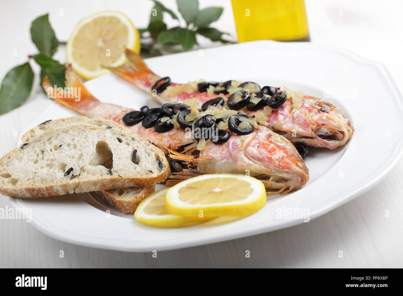 Gebackene goatfishes mit Oliven-, Zitronen-, und Ciabatta Stockfoto