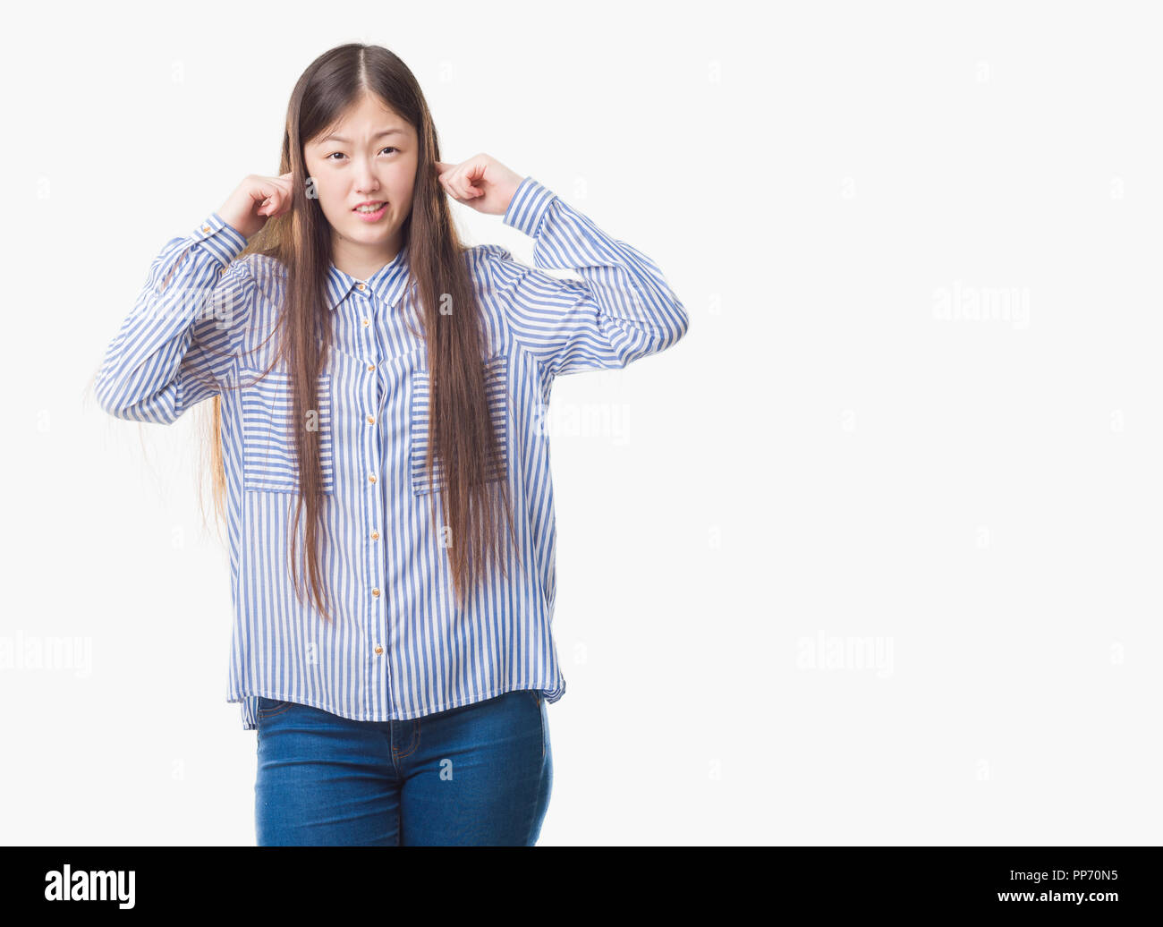 Junge chinesische Frau über isolierte Hintergrund die Ohren mit Fingern mit genervten Ausdruck für den Lärm der laute Musik. Taube Konzept. Stockfoto