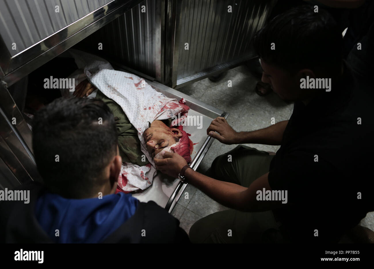 Gaza, Gazastreifen, palästinensischen Gebiet. 23 Sep, 2018. Die Palästinenser betrachten den Körper von Emad Ashtawi, 21, die Toten durch die israelischen Streitkräfte bei Zusammenstößen in Zelten Protest erschossen wurde an der Israel-Gaza Grenze, in al-shifa Hospital in Gaza-stadt am 23 September, 2018 Credit: Mahmoud Nasser/APA-Images/ZUMA Draht/Alamy leben Nachrichten Stockfoto