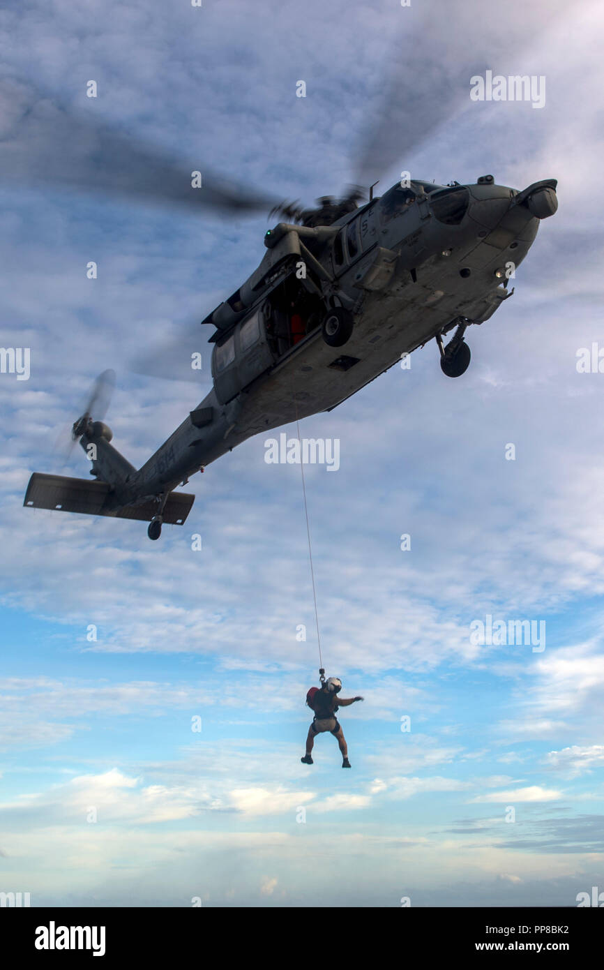 180922-N-WM 647-4041 philippinischen Meer (Sep. 22, 2018) Naval Aircrewman (Hubschrauber) 3. Klasse Jose Mejia, von Houston, verwendet ein Rescue hoist selbst von einem MH-60S Sea Hawk Hubschrauber zu senken, um den "goldenen Falken "Hubschrauber Meer Combat Squadron (HSC) 12 der Flight Deck an Bord der Arleigh-Burke-Klasse geführte Anti-raketen-Zerstörer USS Benfold (DDG65) während einer Suche und Rettung übung, als Teil der Valiant Shield 2018. Valiant Shield ist ein nur in den USA, zweijährige Feld Training übung (Ftx) mit einem Fokus auf Integration der gemeinsame Ausbildung in ein Blau - Wasser Umwelt unter den US-Streitkräften. Dieser Trai Stockfoto