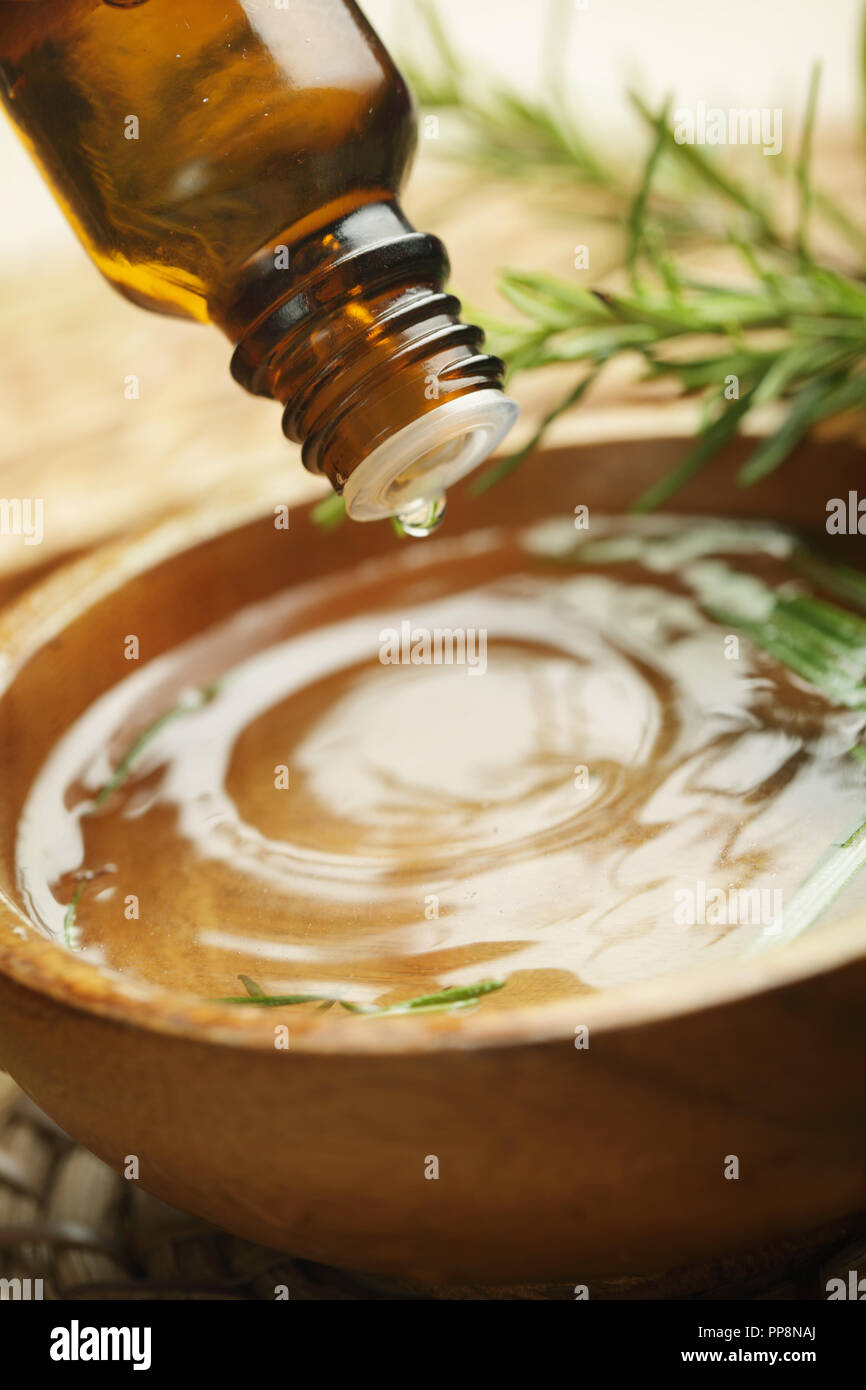 Tropfen Aromaöl über die hölzerne Schüssel Stockfoto