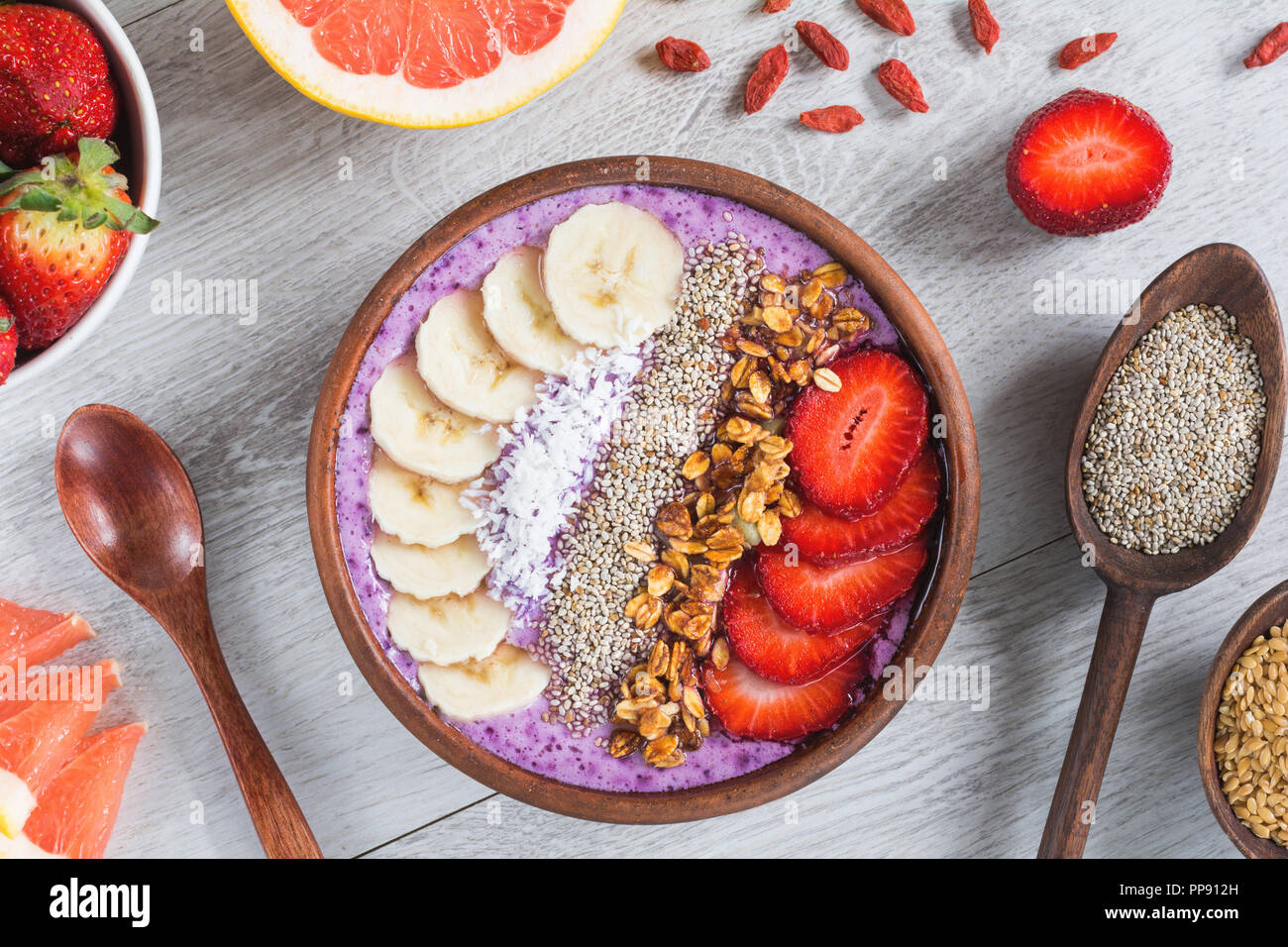 Acai smoothie Schüssel mit superfoods. Smoothy Schüssel gefüllt mit Banane, Chia Samen, Kokos, Erdbeere und Müsli Stockfoto