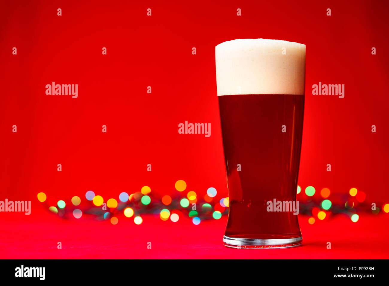 Glas Bär oder Ale mit unscharfen Weihnachtsbeleuchtung im Hintergrund Stockfoto