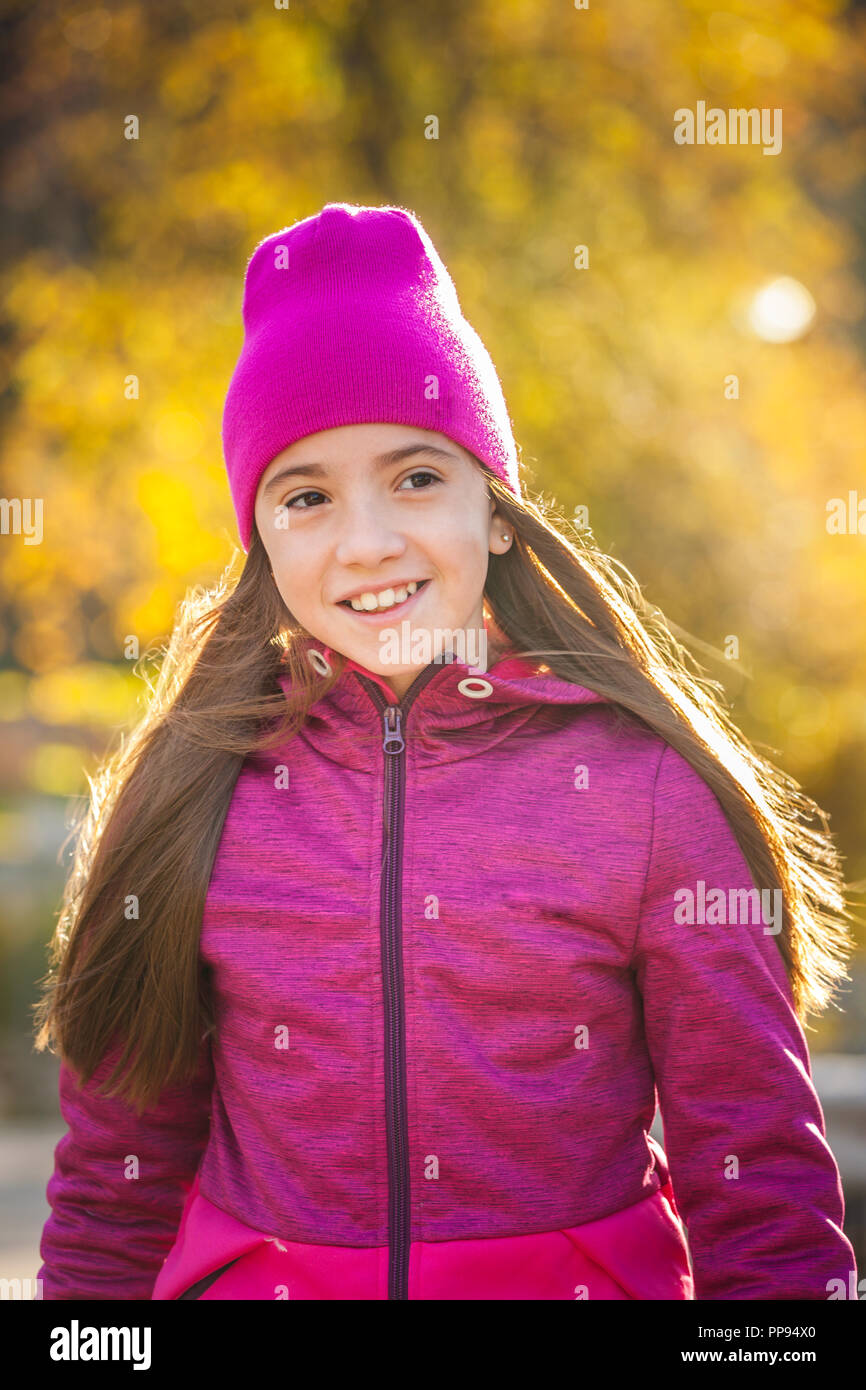 Lächelnd weibliche Teenager mit langen Haaren und Sportswear Wandern im Herbst morgen Stockfoto
