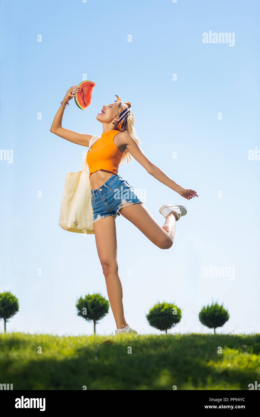 Freudige nette Frau springen auf das Gras Stockfoto Freudige nette Frau springen auf das Gras Stockfoto