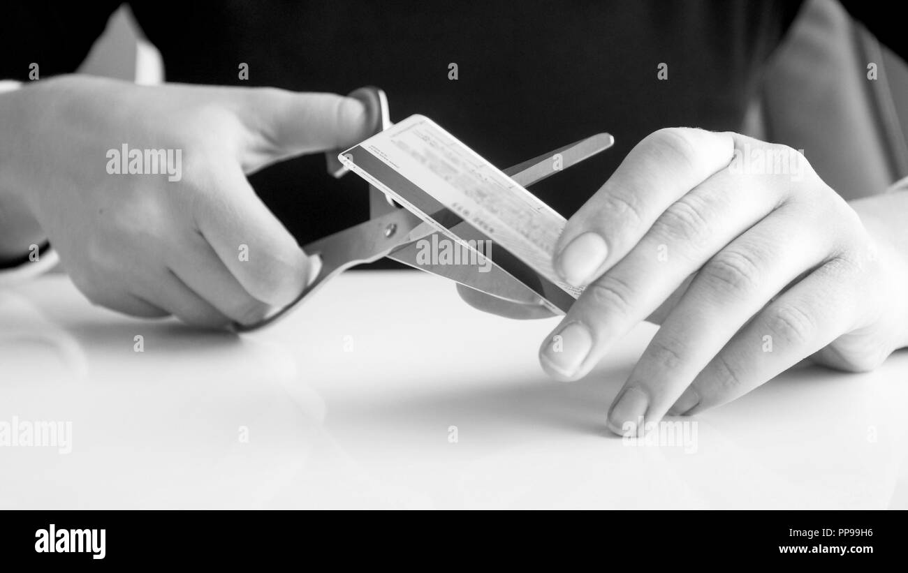 Schwarz-weiß-Bild der weiblichen Bank Arbeiter schneiden Kreditkarte Stockfoto
