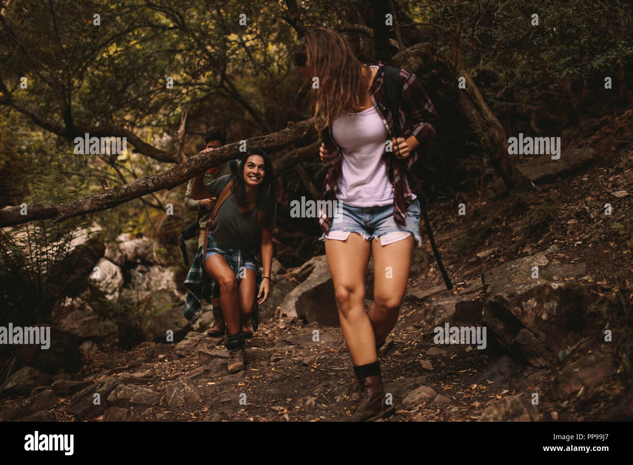 Junge Frauen gehen durch einen Mountain Trail. Junge Menschen wandern in die Berge. Stockfoto