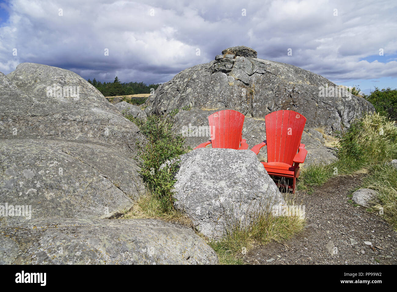 Zwei rote Liegestühle zwischen den Felsen des Fisgard Insel. Stockfoto