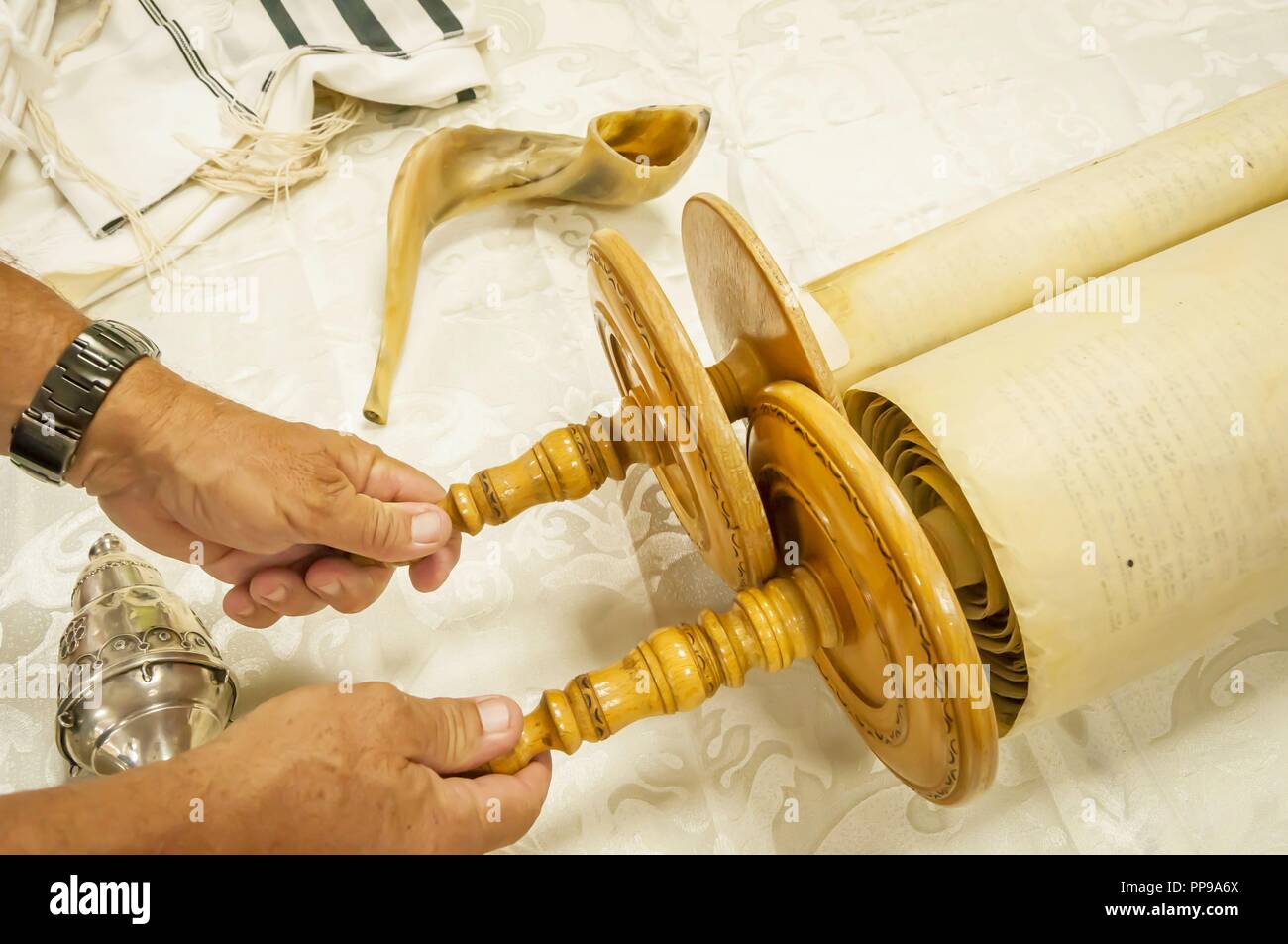 Hände von einem kaukasischen Mann hält die Griffe der Thorarollen. Sefer Torah, megilla, Yom Kippur stock Bild. Rosch Haschanah das Jüdische Neue Jahr Gebet Stockfoto