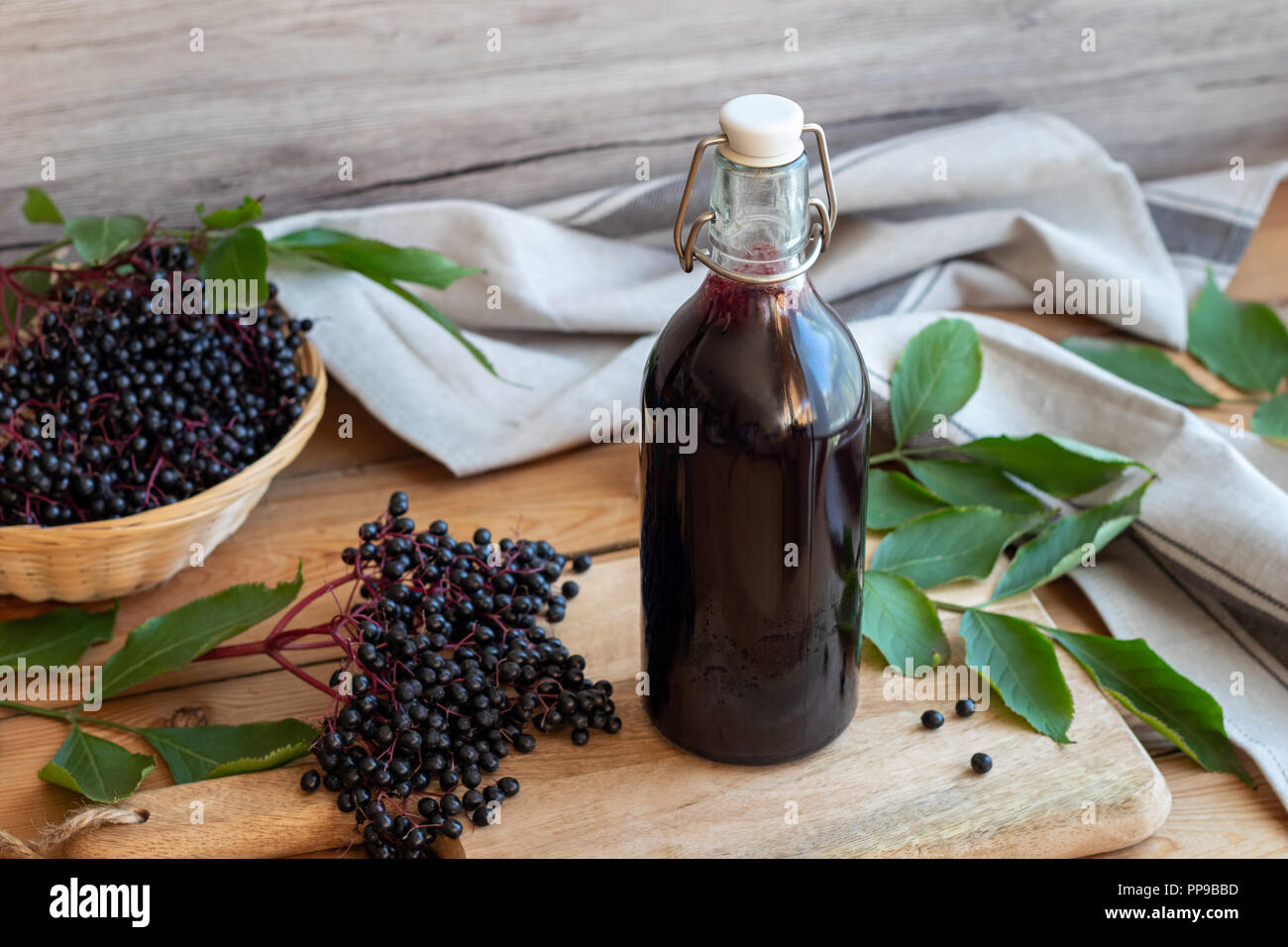 Eine Flasche schwarzen Holunder Sirup mit frischen Beeren Stockfoto