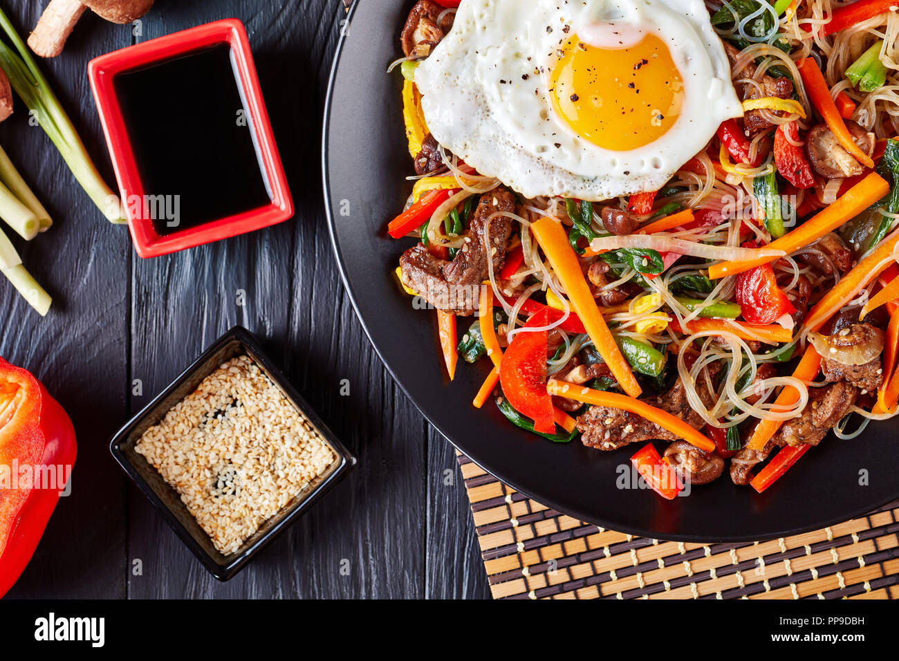 Japchae, Glasnudeln mit Stir gebratenes Gemüse: Karotten, rote Paprika, Spinat, Zwiebeln, Shiitake Pilze, Knoblauch und Rindfleisch, mit Sesam gekleidet Stockfoto