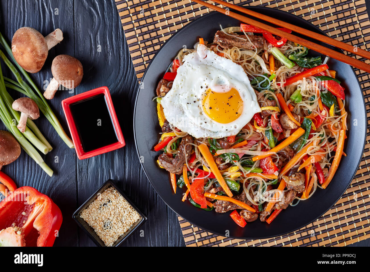 Süße und herzhafte koreanischen Japchae: bouncy Zellophan Nudeln mit knackigem Gemüse gemischt: Spinat, roter Paprika, Zwiebeln, Möhren, Knoblauch, shiitake M Stockfoto