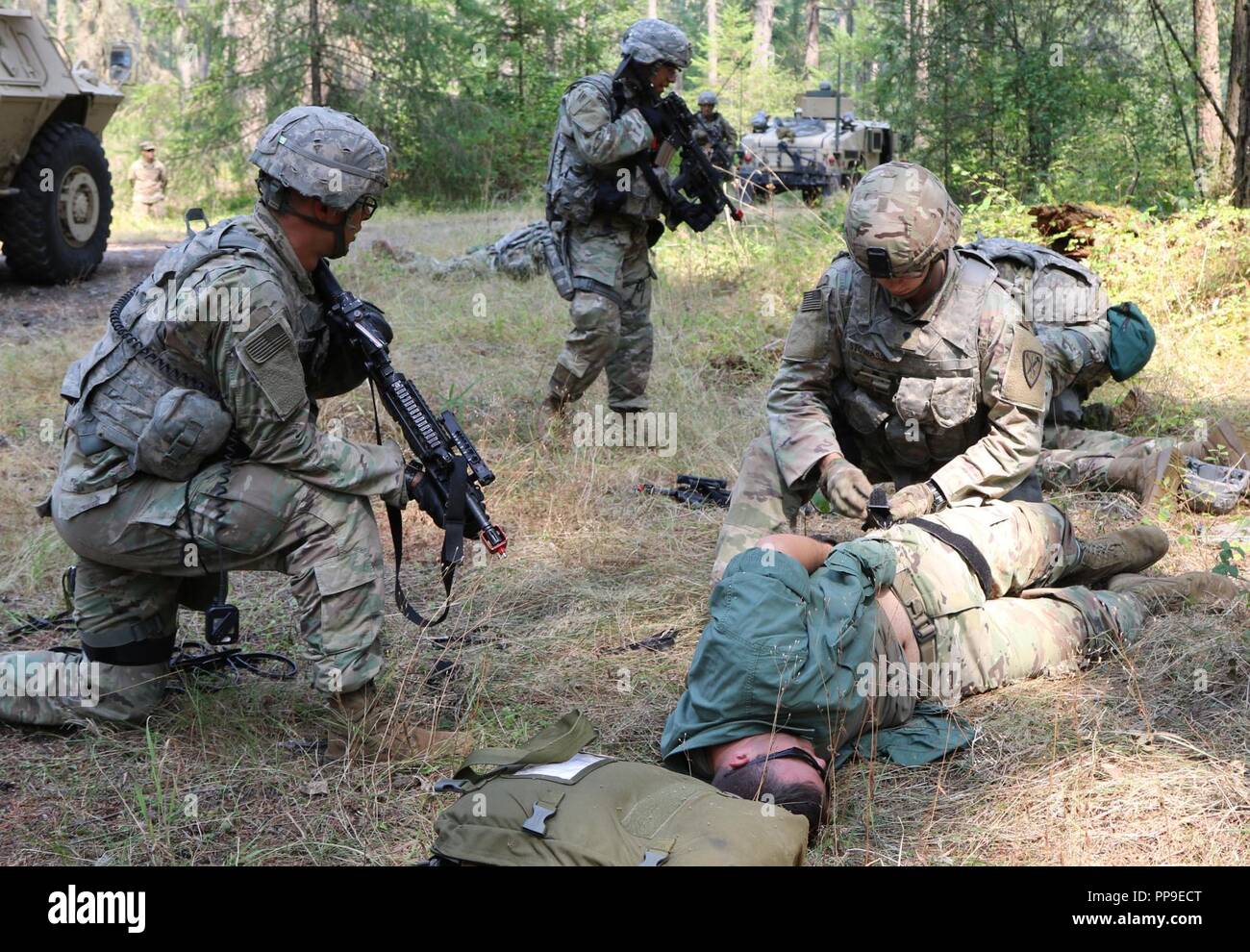 Soldaten der 170th Military Police Company, 504th Military Police Battalion, 42th Military Police Brigade erste Hilfe für die verwundeten Gefangenen verwalten während des Trainings auf Joint Base Lewis-McChord, Washington, den 13. August 2018 Stockfoto