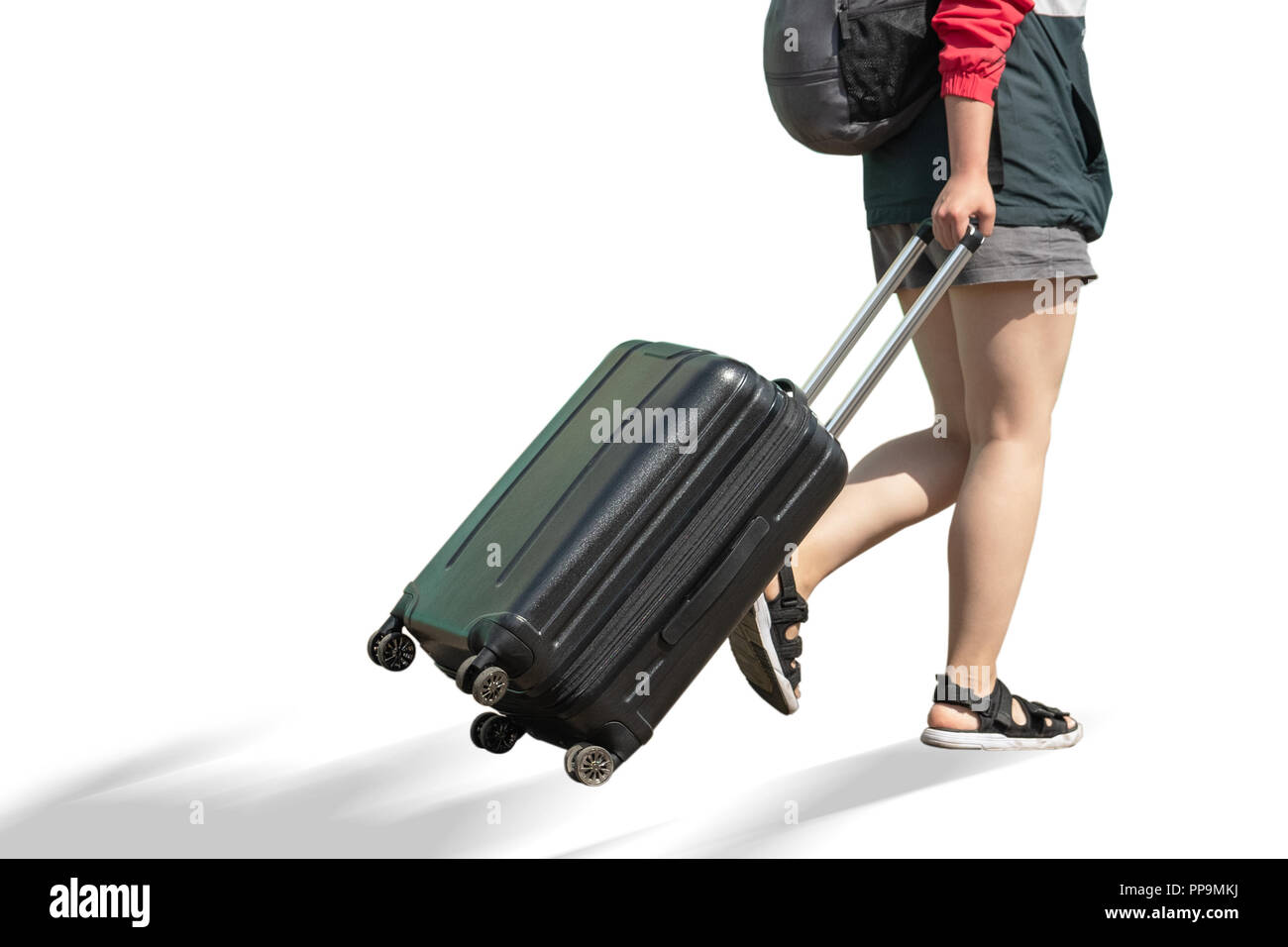 Den unteren Teil des Körpers eines Mädchens mit einem Koffer. Das Mädchen kommt mit einem Koffer. Stockfoto