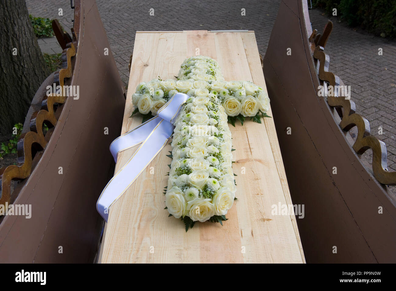Kreuz aus Blumen auf einem Sarg auf einem charlot Stockfoto