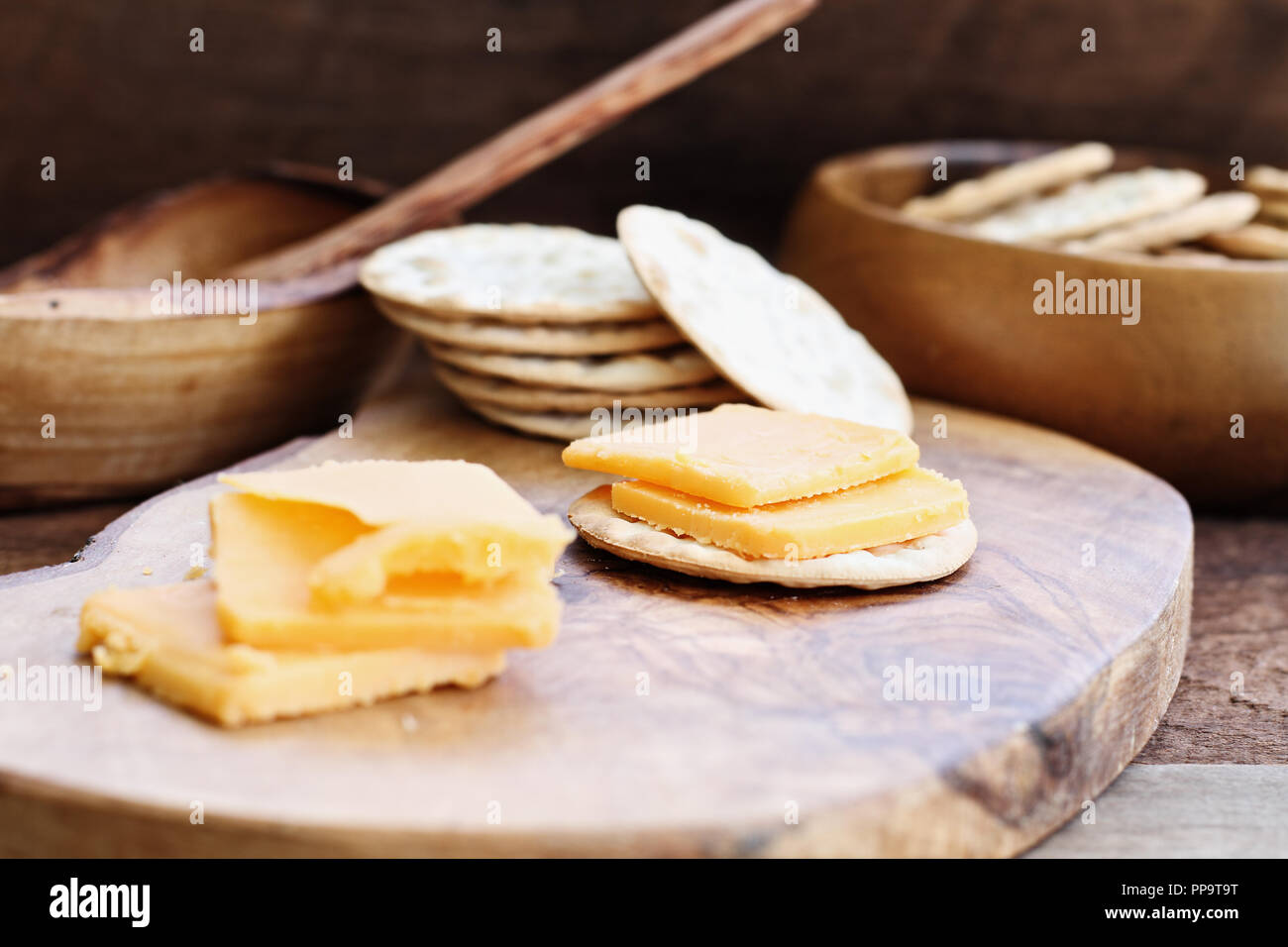 Cheddar Käse und Cracker Vorspeise über eine rustikale Hintergrund. Stockfoto