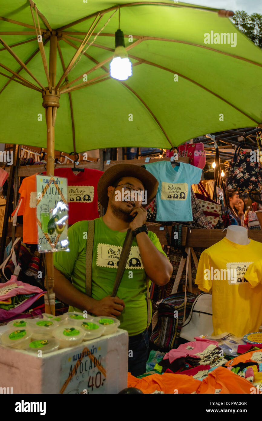 Kaufmann auf dem Telefon am Sonntag Walking Street Market in Chiang Mai, Thailand Stockfoto