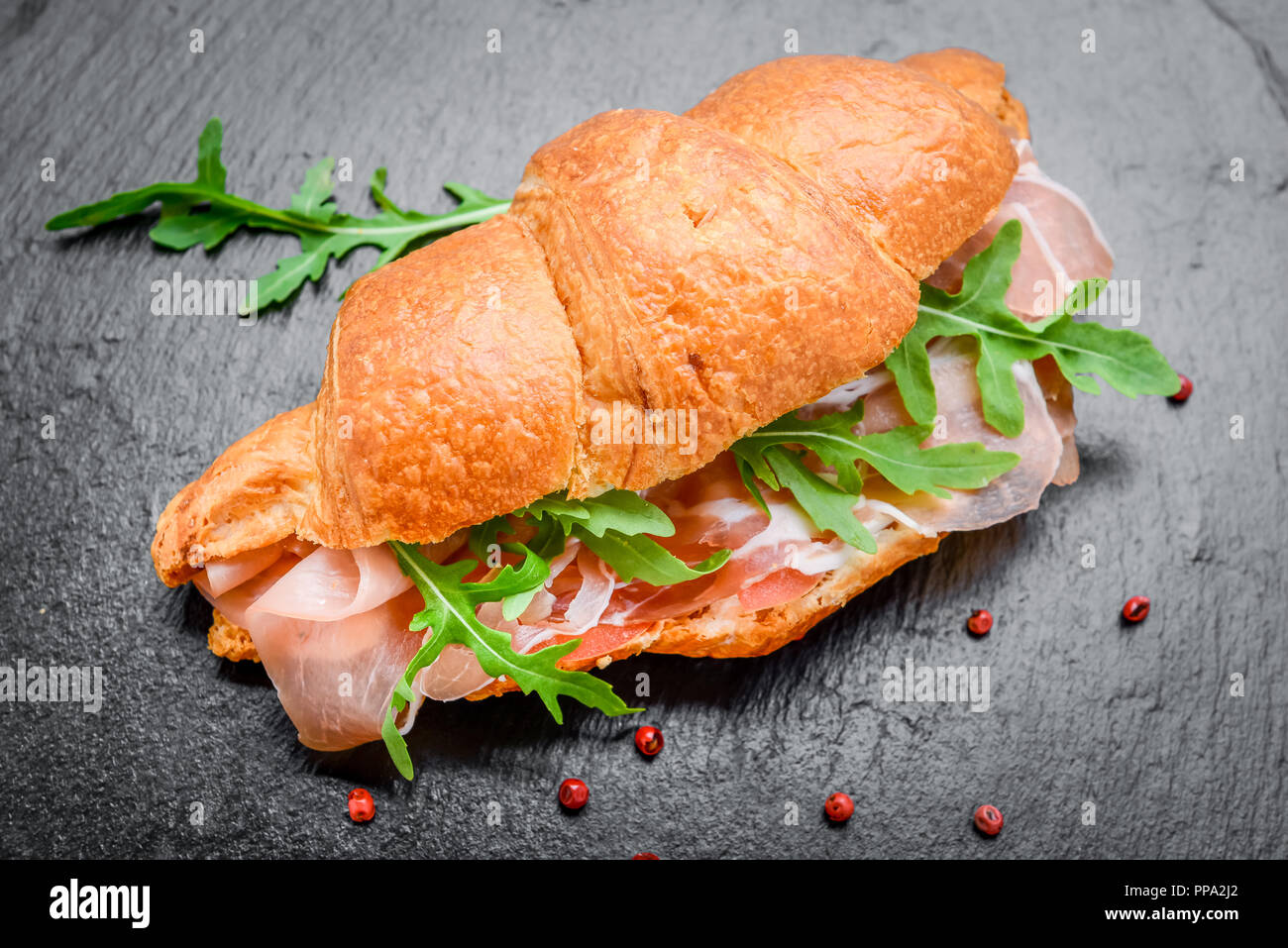 Frisches Croissant mit Schinken und Salat Blatt Stockfoto