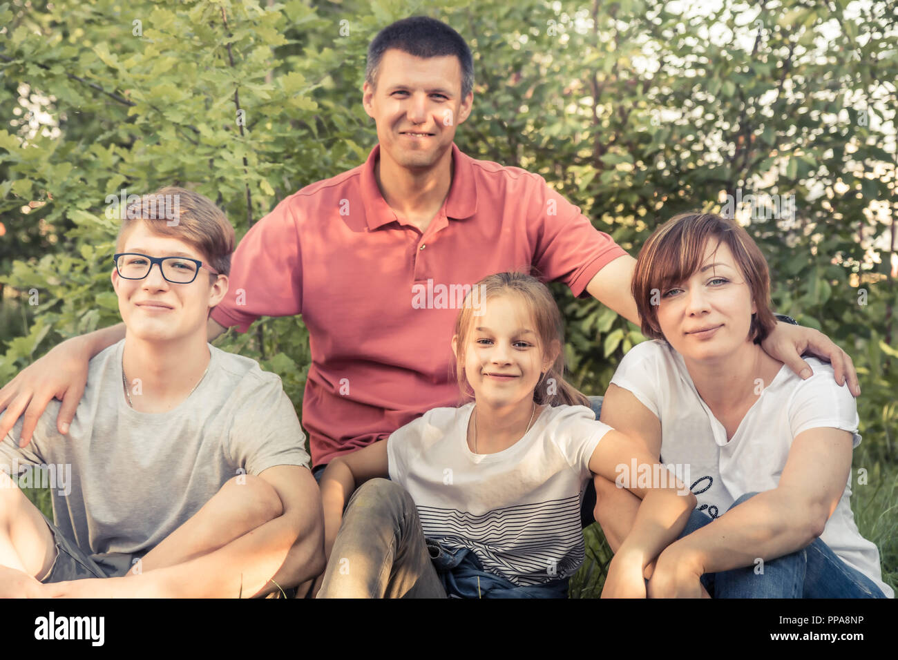 Gerne europäische Familie zusammen, die im Freien Porträt im Sommer Park sitzen auf Gras Stockfoto