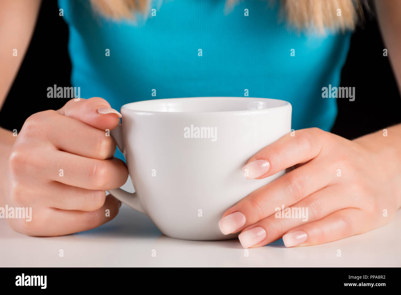 Frau Hände mit Ombre Maniküre holding Tasse Kaffee oder Tee auf weißem Schreibtisch. Schönheit und Maniküre Konzept Bild. Close Up, selektiver Fokus Stockfoto