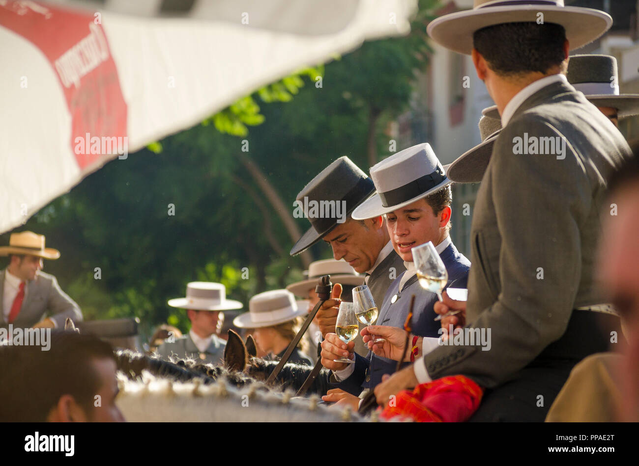 Einige junge spanische Reiter an der Bar, trinken Sherry, spanische Hüte tragen, während der jährlichen Reiten Veranstaltung. Fuengirola, Andalusien. Stockfoto