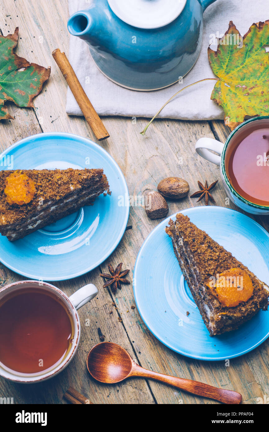 Karottenkuchen (hausgemachte Desserts) Cinnamon Sticks whith und mit Gewürzen und Tasse Tee auf Holz- Hintergrund eingerichtet. Stockfoto