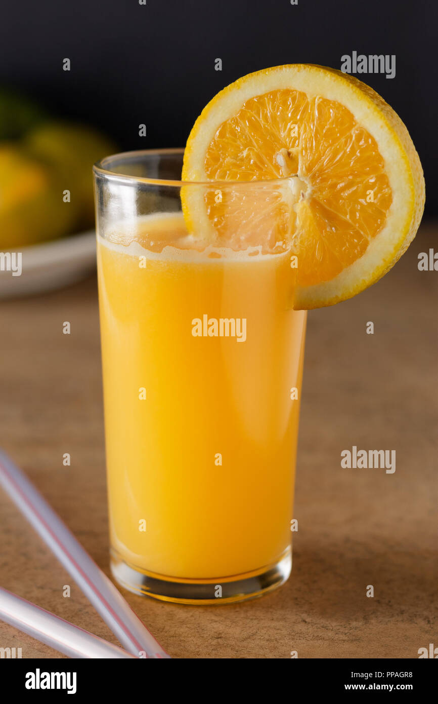 Großes Glas Orangensaft auf einem Holztisch und dunklen Hintergrund. Stockfoto