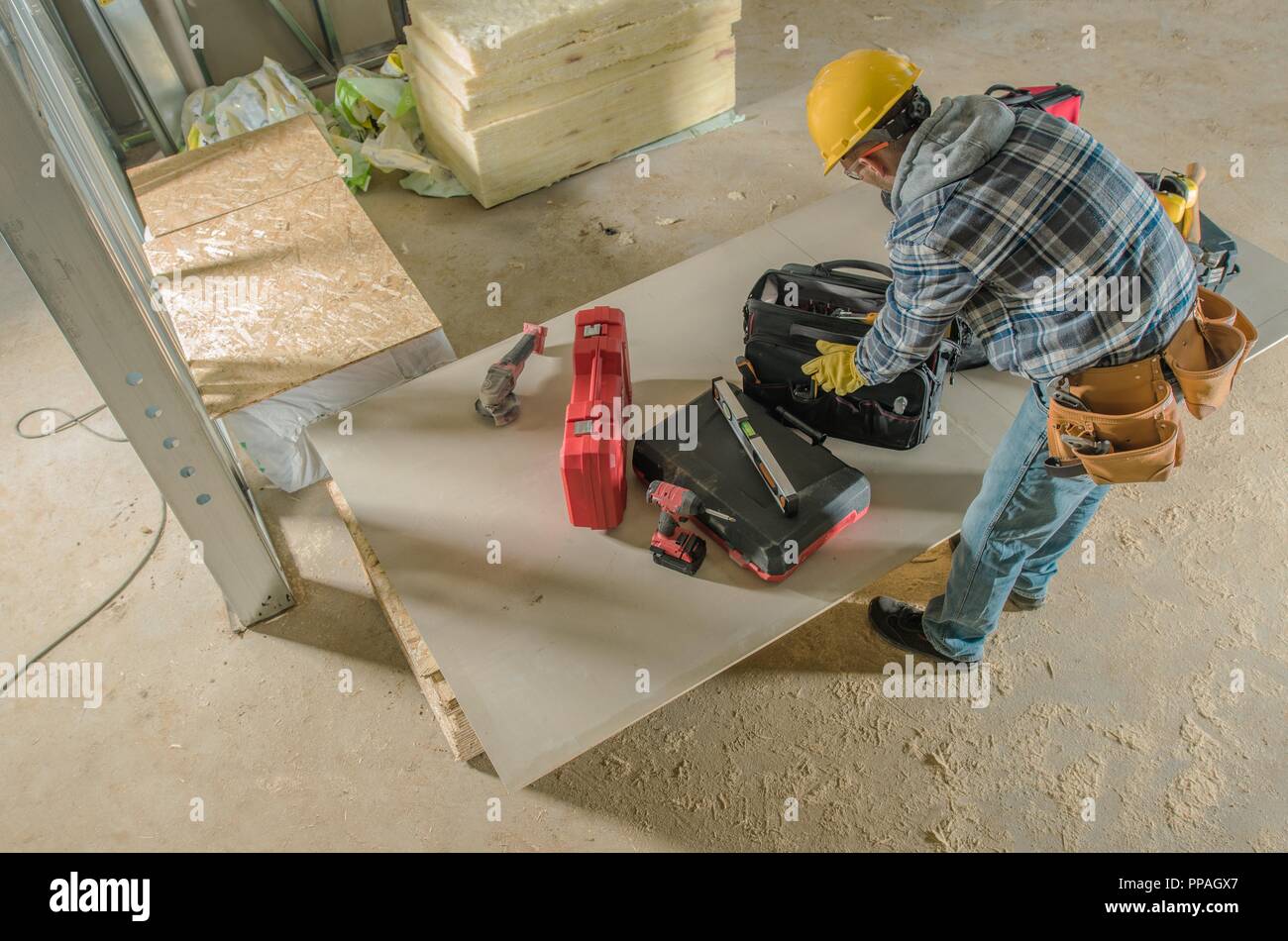 Bau Job zu tun. Kaukasische Auftragnehmer Arbeiter in seinem 30s im Inneren neu entwickelten Stahlgebäude. Stockfoto