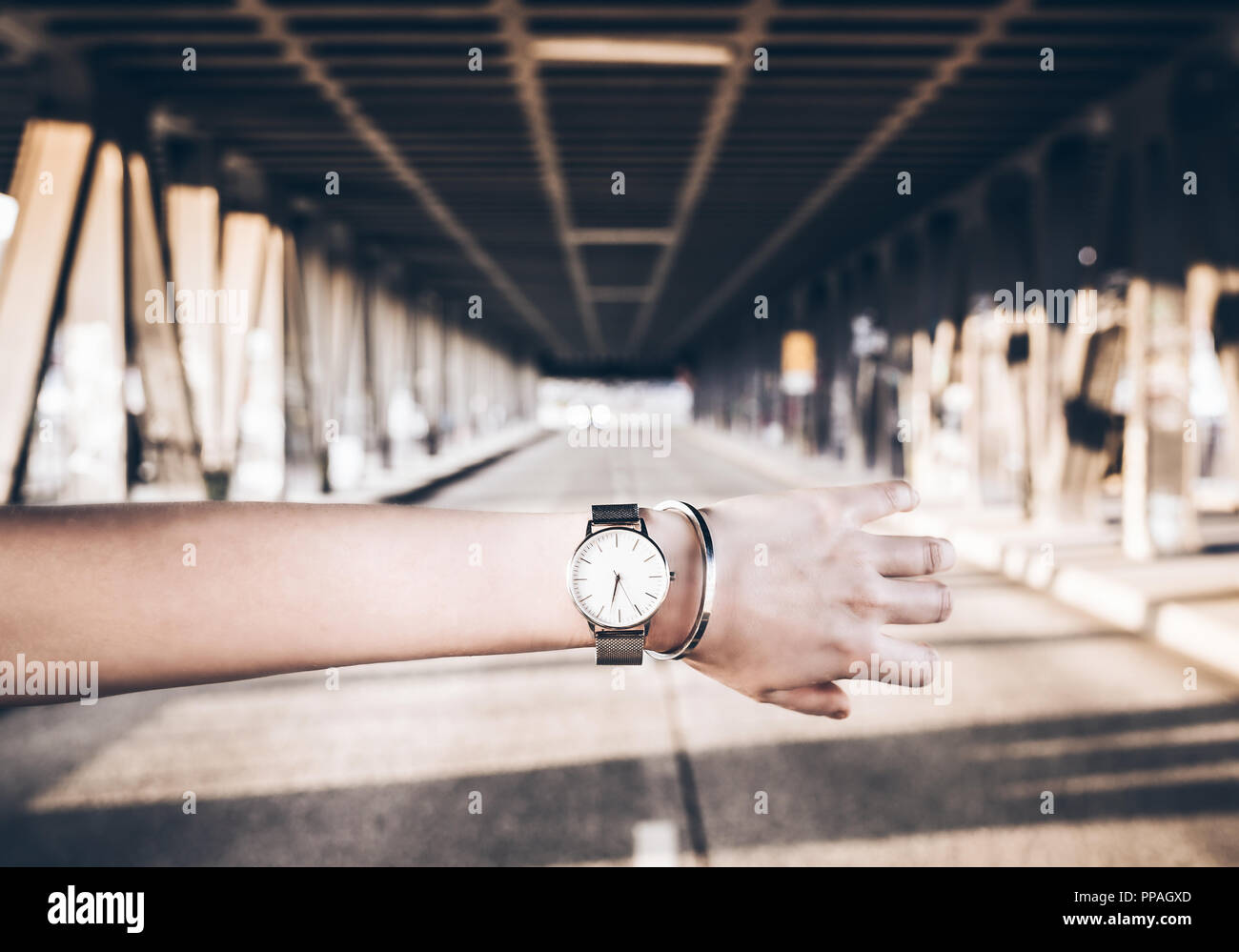Armbanduhr und Armband auf dem Arm gegen die Stadt. Stockfoto