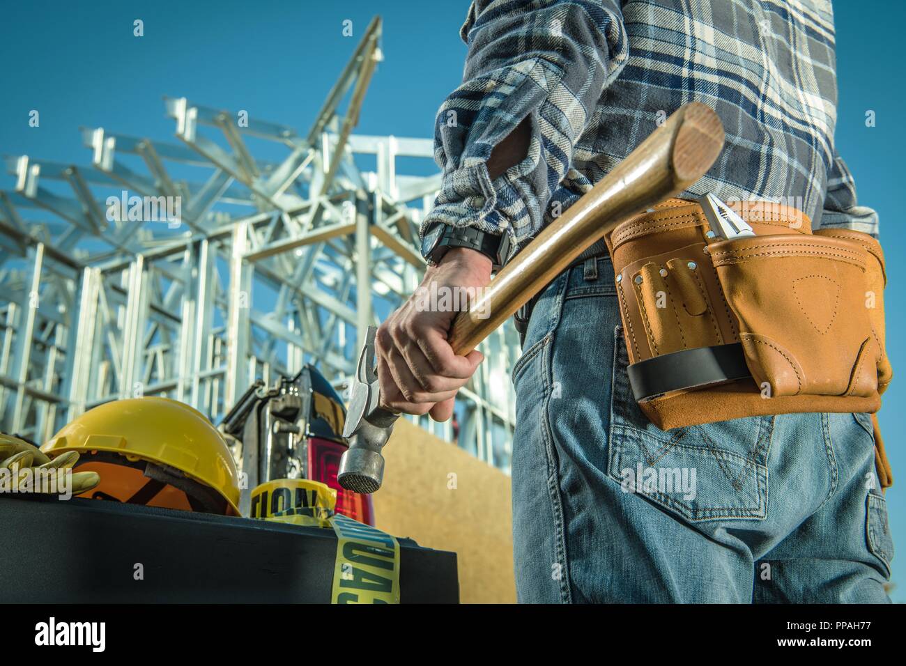 Kaukasische Stahlbau Arbeiter mit großen, professionellen Hammer vor der Baustelle. Stockfoto