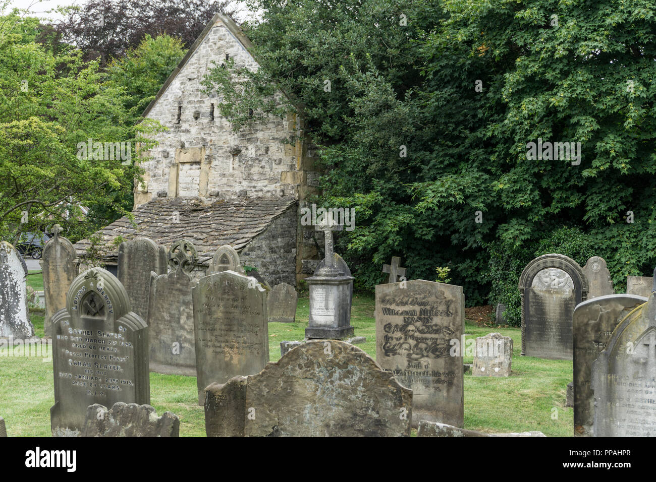 Alte verwitterte Grabsteine auf dem Friedhof, Kirche der Heiligen Dreifaltigkeit, Ashford im Wasser, Derbyshire, Großbritannien Stockfoto