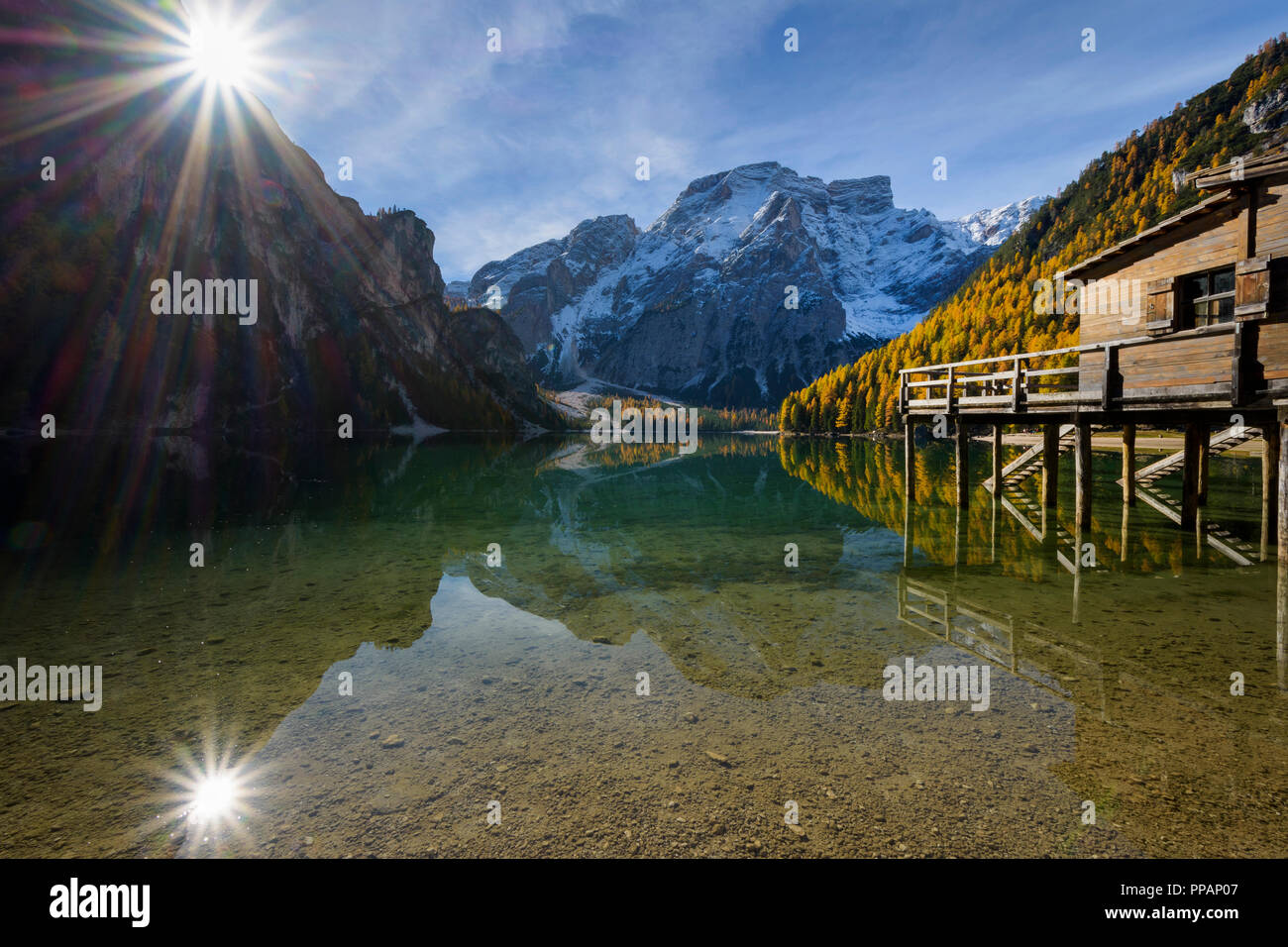 Boot Haus mit Sonne und Croda del Becco, Seekofel, im See im Herbst reflektiert, Pragser See, Lago di Braies, Pragser Wildsee, Provinz Bozen, Bozen Stockfoto