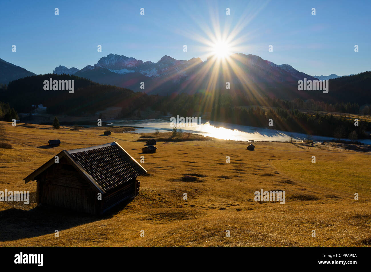 Sonnenaufgang über Karwendelgebirge mit gefrorenen See und Heuscheune, Stadel, See, geroldsee Wagenbruechsee, Gerold, Krün, Krun, Oberbayern, Bavar Stockfoto