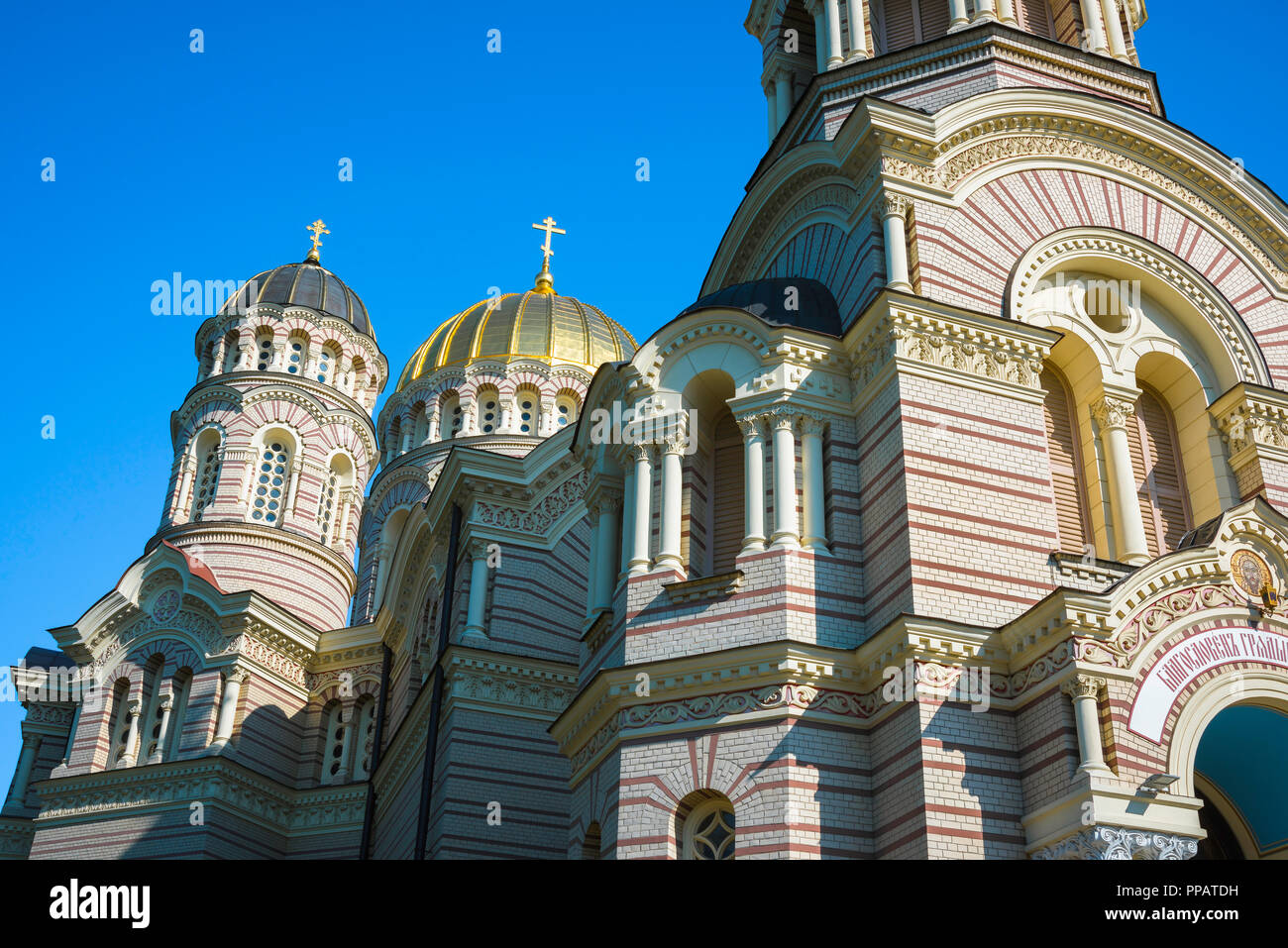 Riga russisch-orthodoxen Kathedrale, Sicht auf die arcading und zwei-ton Mauerwerk an der Fassade der Geburt Christi Kathedrale im Zentrum von Riga, Lettland. Stockfoto