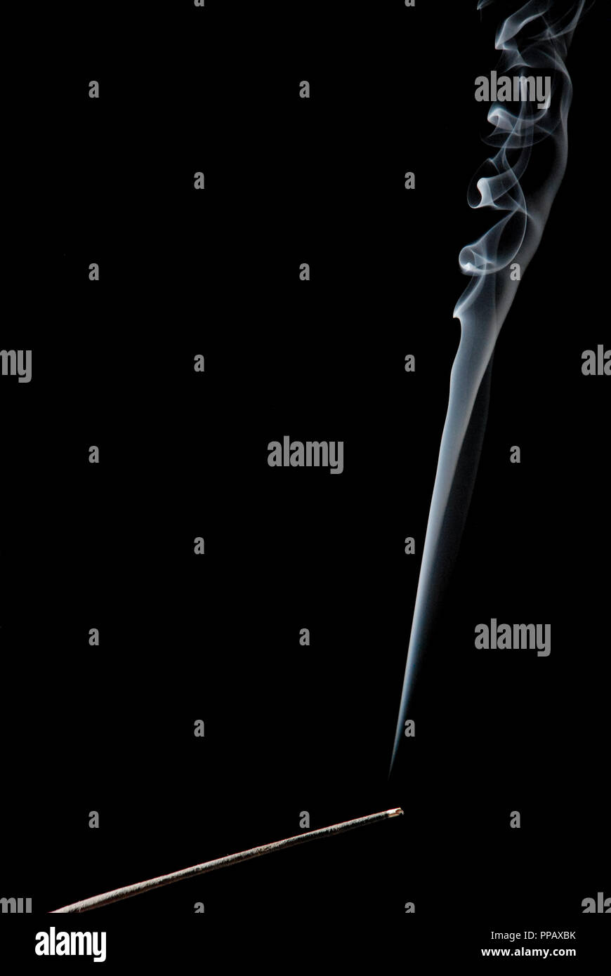 Räucherstäbchen mit Rauch auf schwarzem Hintergrund Stockfoto